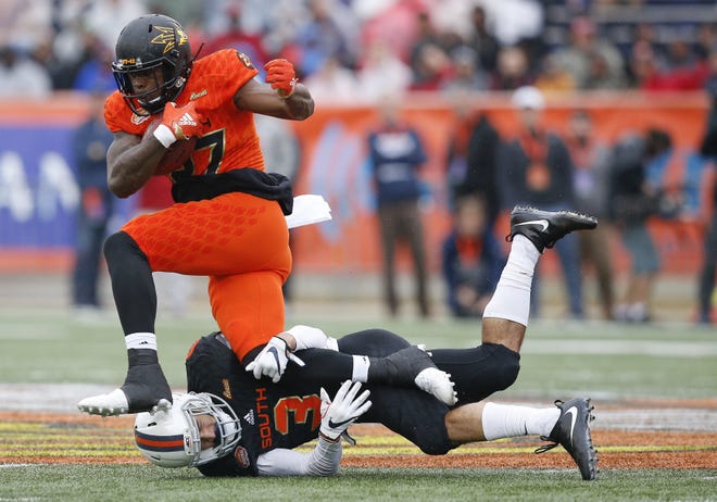 North Squad running back Kalen Ballage, of Arizona State, avoids the tackle against South Squad's Quin Blanding, of Virginia, during the first half of the Senior Bowl college football game in Mobile, Ala., Saturday. [BRYNN ANDERSON / ASSOCIATED PRESS]