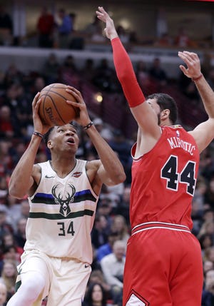 Milwaukee Bucks forward Giannis Antetokounmpo, left, looks to the basket as Chicago Bulls forward Nikola Mirotic guards during the first half of an NBA basketball game Sunday in Chicago. (NAM Y. HUH/THE ASSOCIATED PRESS]
