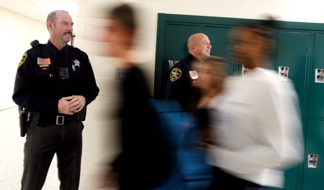From left, school resource officers Robby Barr and Lt. Steve McKee keep an eye on students during classroom change at Crest High School on Friday. [Brittany Randolph/The Star]