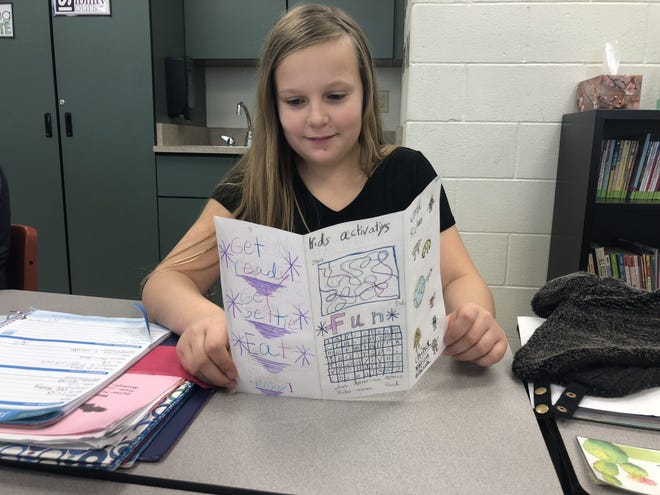 Pearl City fifth-graders recently created menus with food from around the world as part of their language classes. Pictured: Sylvia Schnoor shares her world menu. [PHOTO PROVIDED]