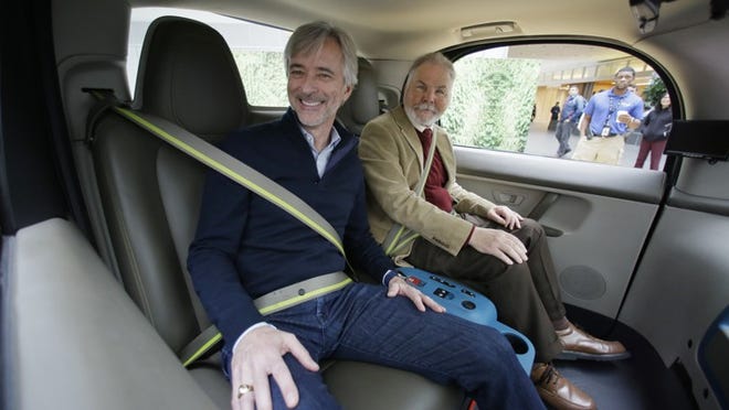 Waymo CEO John Krafcik, left, sits with Steve Mahan inside a driverless car Dec. 13, 2016, in San Francisco. The self-driving car project that Google started seven years ago has grown into a company called Waymo. In 2015, Mahan became the first member of the public to ride in Google’s self-driving prototype, alone and on public roads. (AP Photo/Eric Risberg)
