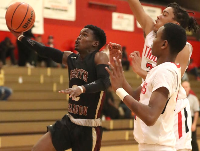 North Marion's Marquez Reaves (2) drives to the hoop past Dunnellon's Carlos Grubbs (11) and Caleb Schroeder (21) during the Colts' 51-44 at Dunnellon High School in Dunnellon on Tuesday. [Bruce Ackerman/Staff photographer]