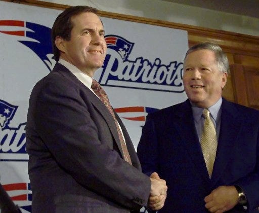 Newly-hired New England Patriots' head coach Bill Belichick, left, shakes hands with Patriots' owner Robert Kraft, seconds before the start of a news conference at Foxboro Stadium on Jan. 27, 2000.