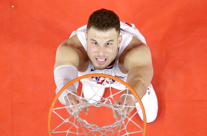 Blake Griffin hangs on the net after throwing the ball out of bounds while trying to pass it to guard Lou Williams with seconds left in a game between the Clippers and Timberwolves on Jan. 22 in Los Angeles. [The Associated Press / Mark J. Terrill]