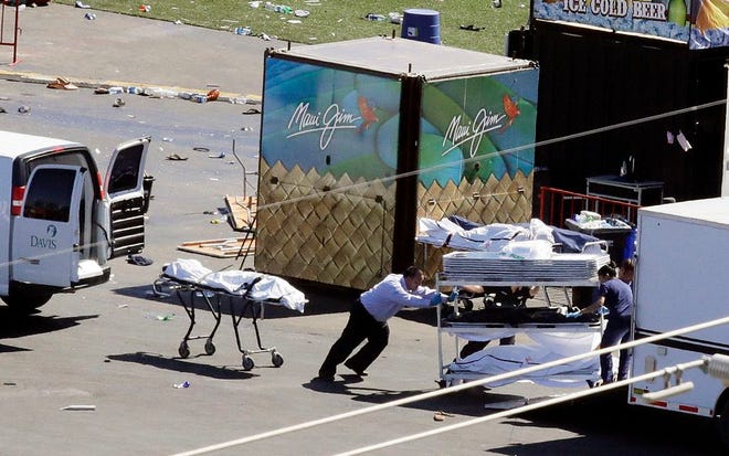 FILE--In this Oct. 2, 2017, file photo, investigators load bodies from the scene of a mass shooting at a music festival near the Mandalay Bay resort and casino on the Las Vegas Strip in Las Vegas. Two Nevada judges in Las Vegas have ordered the release of search warrant records and autopsy reports related to the deadliest mass shooting in modern U.S. history, with some information redacted.(AP Photo/Chris Carlson, file)