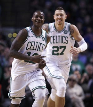Boston Celtics guard Terry Rozier (12) smiles as he heads up court with forward Daniel Theis after completing a triple-double Wednesday in Boston. [Charles Krupa/AP]