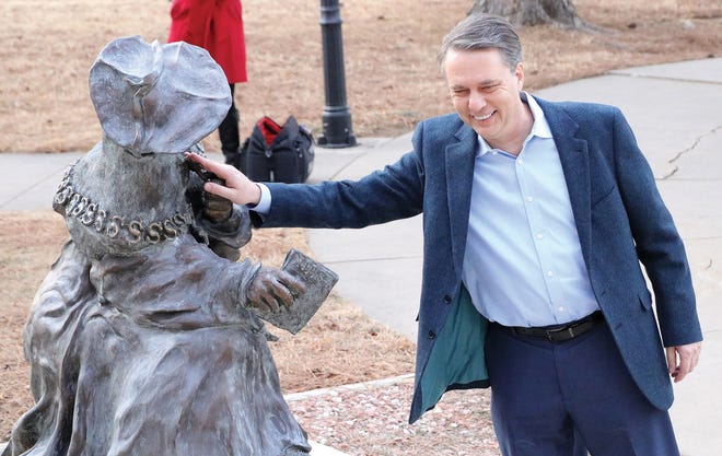 Gov. Jeff Colyer touches the statue of Thomas More on Wednesday morning at the entrance to Thomas More Prep-Marian High School in Hays. Colyer attended Mass at his alma mater with several classmates and teachers before his inauguration in Topeka. [Juno Ogle/The Hays Daily News]