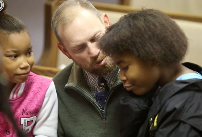 Pastor Joey Gilbert of Carnesville, Georgia, talks to Alasjah Haynes, 7, of Waveland, and her sister, Jada, 12, before services in mid-December at Bayside Baptist Church in Waveland, Mississippi. Gilbert travels 1,000 miles roundtrip three weekends each month to pastor the small church. [John Fitzhugh/Biloxi Sun Herald/TNS]