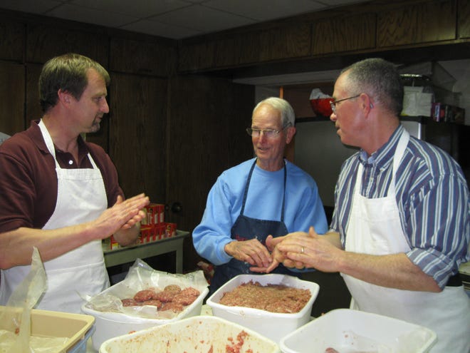 (From left) John Burke, Richard Thomas and Glenn Sheets help prepare homemade sauage for a prior Men of Grace Espiscopal Church Shrove Tuesday Pancake Supper. [Contributed photo]