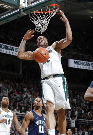 Michigan State's Miles Bridges dunks as Penn State's Lamar Stevens (11) and Michigan State's Nick Ward watch during the first half Wednesday in East Lansing, Mich. [AL GOLDIS/THE ASSOCIATED PRESS]