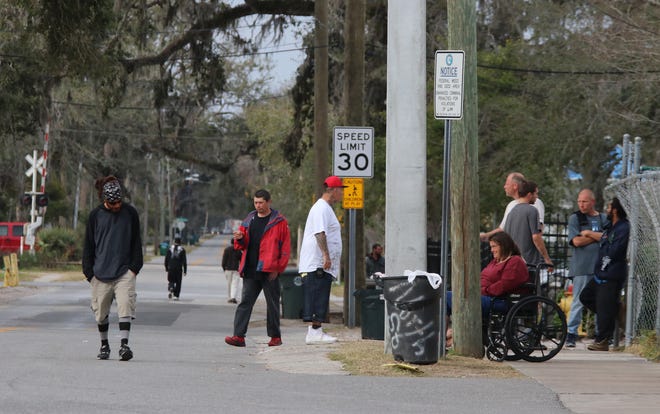 Homeless people gather on North Street in Daytona Beach on Friday. Since Halifax Urban Ministries is getting ready to open a new family shelter in the old Hurst Elementary School, 94 beds will be freed up in the North Street space HUM has rented the past 10-15 years. [News-Journal/Jim Tiller]