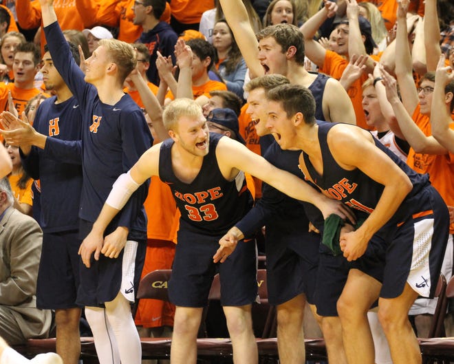 The Hope College men’s bench erupts in excitement as Jeff Goral (center), celebrates with Matt Zandstra (middle right) and Preston Granger (right) during Saturday’s win over Calvin at VanNoord Arena. [Chris Zadorozny/Sentinel staff]