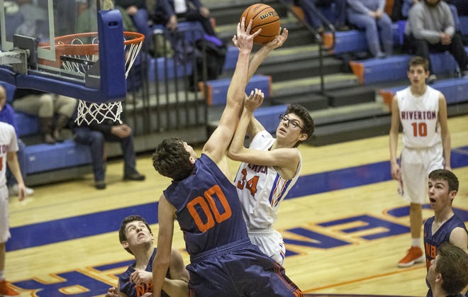 New Berlin's Max Day blocks Riverton's Travis Hogan's shot but is called for a foul at Riverton High School Friday, Feb. 2, 2018. New Berlin defeated Riverton 51-43. [Ted Schurter/The State Journal-Register]