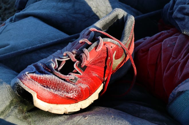 A shoe covered in an icy frost lays outside a tent at the Safe Zone off Clyde Morris Boulevard in Daytona Beach Thursday morning, Jan. 4, 2018. [News-Journal/Jim Tiller]