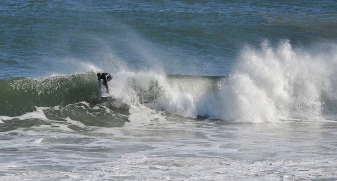 WELLFLEET -- 020518 -- A surfer catches a wave off LeCount Hollow Beach Monday afternoon.