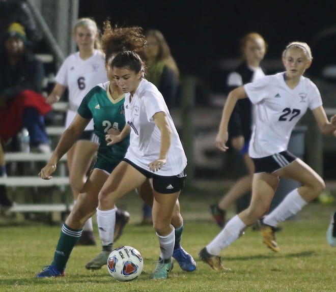 Kayla Fernandez moves the ball near midfield as Niceville player Lincoln in a girls soccer quarterfinal at Niceville. [MICHAEL SNYDER/DAILY NEWS]