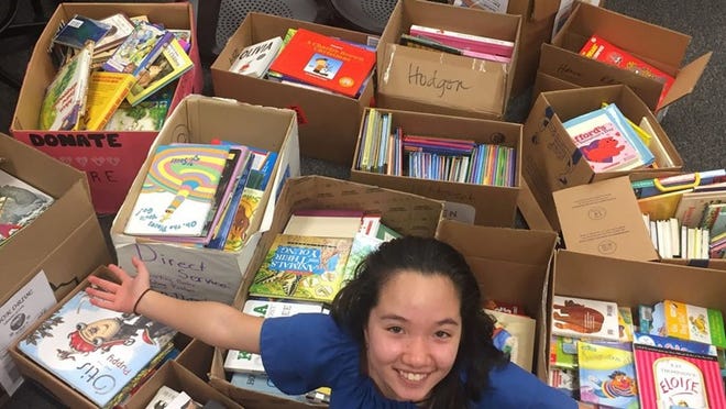 Nicole Frazier, a seventh-grader at Grisham Middle School, helped the school collect more than 600 books for students in Uganda as part of the Libraries of Love IB service project. Courtesy photo