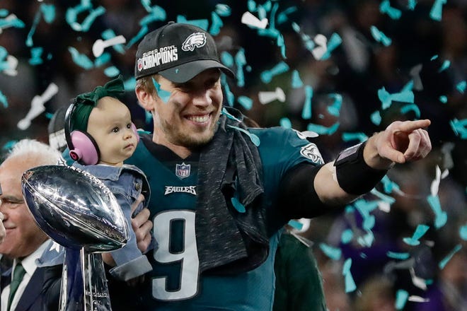 Philadelphia Eagles' Nick Foles holds his daughter, Lily, after beating the New England Patriots in the NFL Super Bowl 52 football game Sunday, Feb. 4, 2018, in Minneapolis. (AP Photo/Frank Franklin II)