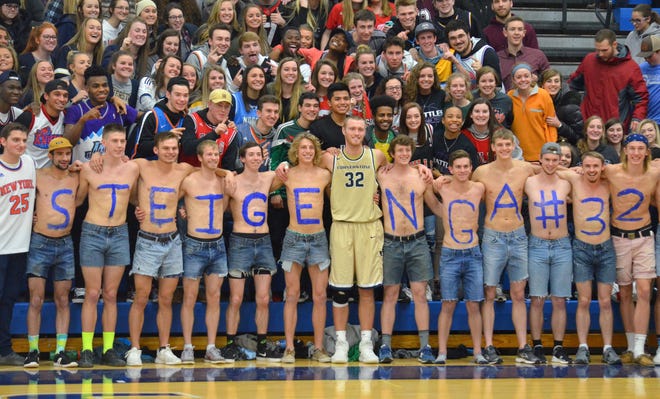 Kyle Steigenga stands with the student section after breaking the all-time career scoring record in the state of Michigan on Wednesday at Mol Arena. [Dan D’Addona/Sentinel staff]