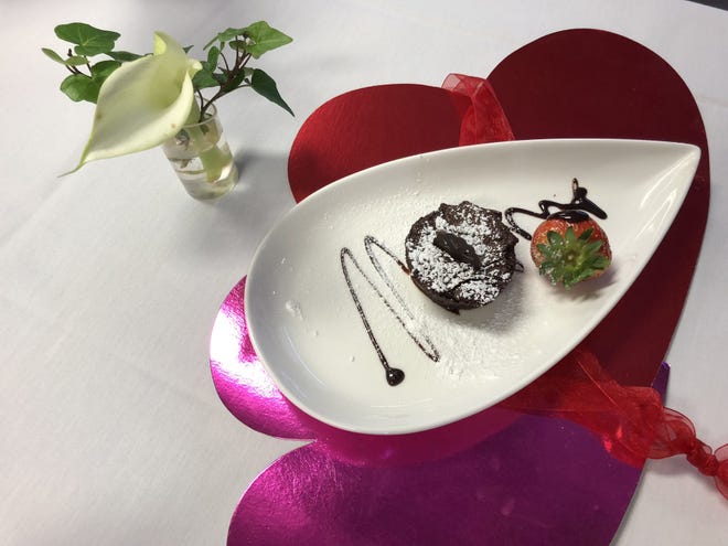 A chocolate soufflé paired with a chocolate drizzled strawberry make for a sweet finish to a Valentine's meal. [PHOTOS BY JAN WADDY/THE NEWS HERALD]
