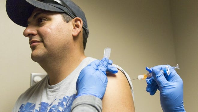 Licensed Vocational Nurse Cynthia Smith gives Willie Chavez a flu shot at the South Austin Regional Clinic on Jan. 24. RICARDO B. BRAZZIELL / AMERICAN-STATESMAN