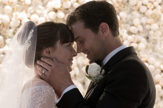 Anastasia (Dakota Johnson) and Christian (Jamie Dornan) exchange vows in "Fifty Shades Freed." [Universal Pictures]