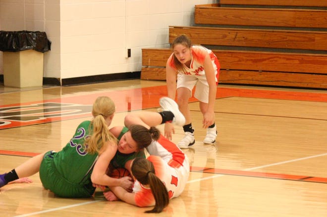 South Fulton’s Sadie Markley (23) and Maddi Coulter and Illini Bluffs’ Hannah Alvey went to the floor in an attempt to corral a lose ball in regional action Tuesday night. The Lady Rebels upset set the No. 2 seed Lady Tigers 41-30 in overtime to advance to Thursday’s regional title game.