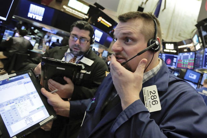 Trader Michael Milano, right, works on the floor of the New York Stock Exchange Thursday. [AP Photo/Richard Drew]