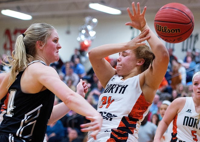 Ledford's McCall Denny (left) knocks the ball out of the grasp of North Davidson's Abby McMillan on Friday night. [Donnie Roberts/The Dispatch]