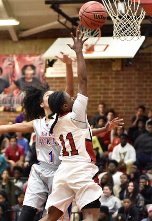 Thomasville's Dee Long goes for a layup while Lexington's Mikenzie Harvin tries to block it on Friday night at Thomasville. [David Yemm for The Dispatch]