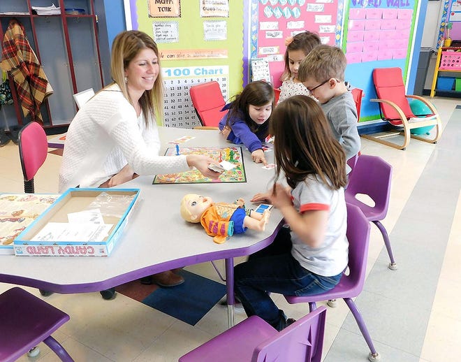 Fisher Elementary School kindergarten teacher Sarah Barberio joins a few of her students in a game of Candyland during Global School Play Day on Thursday at the school. [DONNA THOMPSON/TIMES TELEGRAM]