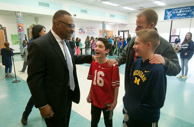 Former Penn State University and NFL star Blair Thomas, left, meets Newtown Elementary School sixth-graders Charlie Halikman, center, and Aidric Norgren and Principal Kevin King before speaking at an assembly Friday. [BILL FRASER / STAFF PHOTOJOURNALIST]