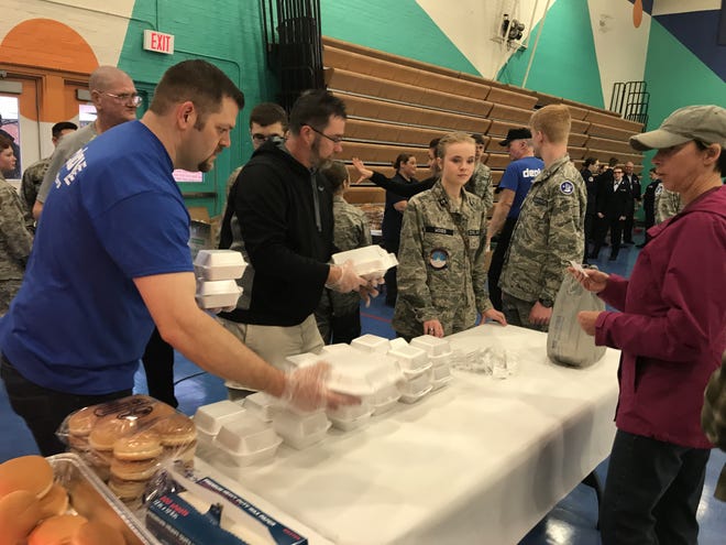 Phillip Hamrick and Chad Bridges make barbecue plates with cadets for the Shelby Civil Air Patrol at the Deploy Inc. fundraiser. [Joyce Orlando/The Star]