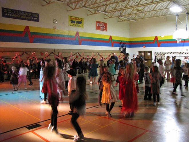 Youngsters dance to the beat in the gym.