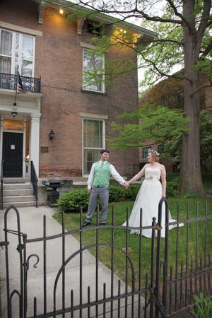 Danielle and Craig Van Aelst pose in front of Kelton House, where their wedding and reception took place.