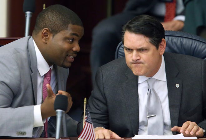 FILE - In this March 9, 2017, file photo, Rep. Byron Donalds, R-Naples, left, confers with Rep. Cord Byrd, R-Neptune Beach, in Tallahassee, Fla. Donalds is the lead sponsor of a proposal that would allow parents whose children have been bullied at public schools to obtain state vouchers to help pay tuition at a private school. (AP Photo/Steve Cannon, File)