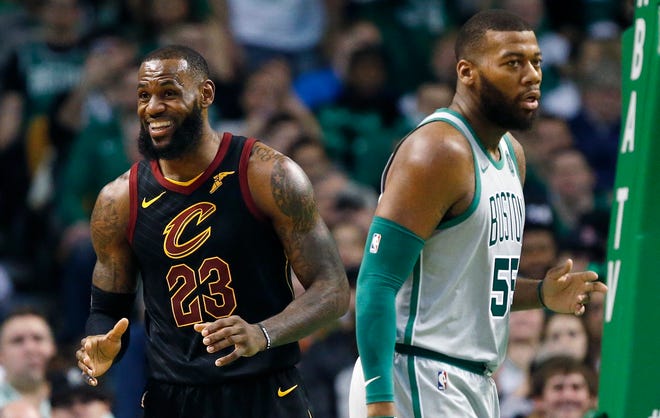 Cleveland Cavaliers' LeBron James (23) reacts to a call beside Boston Celtics' Greg Monroe (55) during the second quarter of an NBA basketball game in Boston, Sunday, Feb. 11, 2018. (AP Photo/Michael Dwyer)