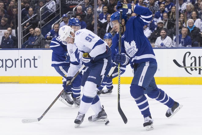 Tampa Bay Lightning centre Steven Stamkos (91) battles for the puck with Toronto Maple Leafs right wing Kasperi Kapanen, right, during first period in Toronto on Monday. [Chris Young/The Canadian Press via AP]