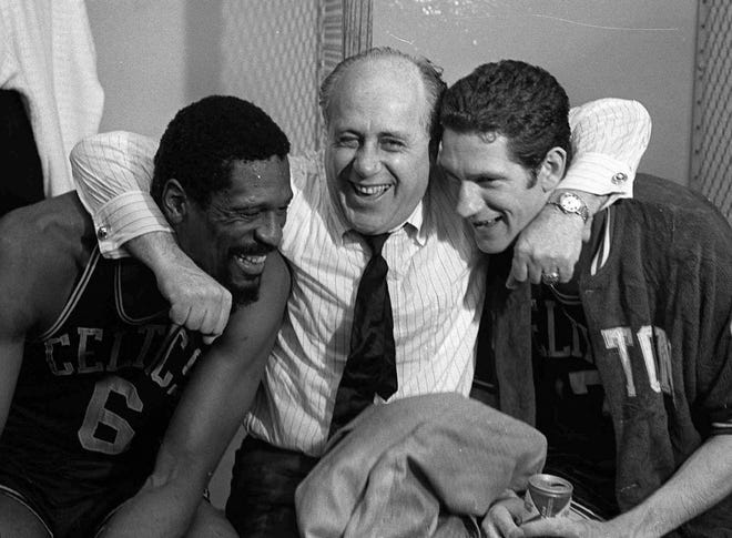 Red Auerbach hugs Bill Russell, left, and John Havlicek, right, after the Celtics' NBA Championship win over the Los Angeles Lakers in Los Angeles on May 3, 1968. [AP Photo/file]