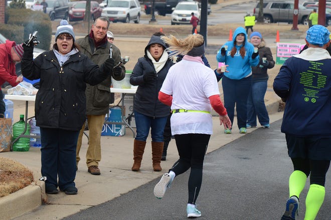 Cheryl Gates from left, Blair Parnell and Yuliana Anaya along with other BancorpSouth employees hand out energy bars and water as runners pass by on Rogers Avenue during the Fort Smith Marathon on Sunday, Feb. 11, 2018 in Fort Smith. [BRIAN D. SANDERFORD/TIMES RECORD]