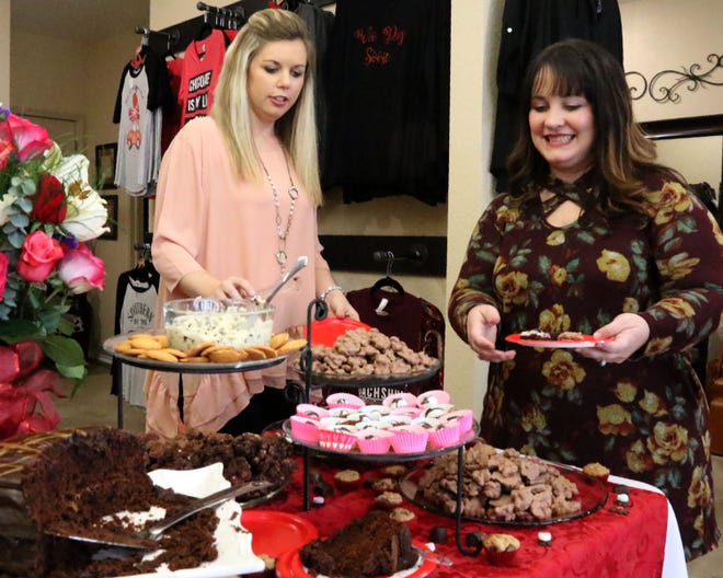 Alicia Jordan, left, and Megan Lindsey take a break from shopping to sample some of the chocolate goodies set out for the third annual Chocolate Extravaganza at La Boutique's, 711 Fayetteville Road, in Van Buren on Saturday, Feb. 10, 2018. The annual shopping and tasting event included custom chocolates, cakes, snacks, hot cooca bar, as well as a kissing booth for photos. [JAMIE MITCHELL/TIMES RECORD]