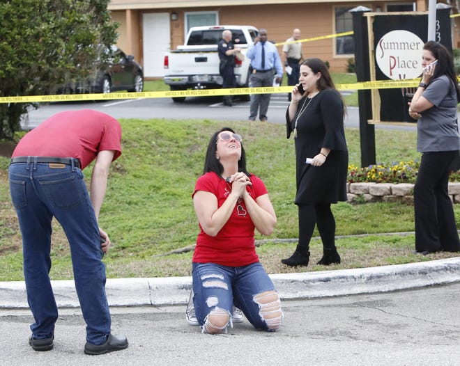 Family and friends of a woman taken hostage by a shooting suspect show relief following the news that she had been found unharmed in Georgia with the suspect. Gainesville police say the suspect fled Summer Place Villas, pictured in background, following a double homicide on Tuesday. [Brad McClenny/Staff photographer]