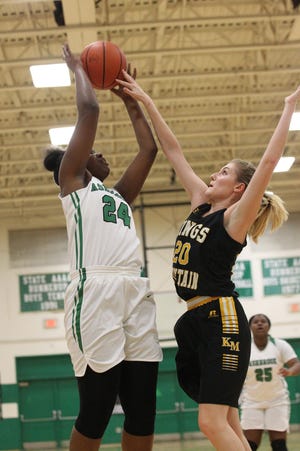 Kings Mountain's Jada Roberts blocks a shot from Ashbrook's Summer Schloss in Wednesday's conference semifinal game. The Green Wave defeated the Mountaineers 80-61 to advance to Friday's Championship game against Forestview. [Brian Mayhew / Special to the Gazette]