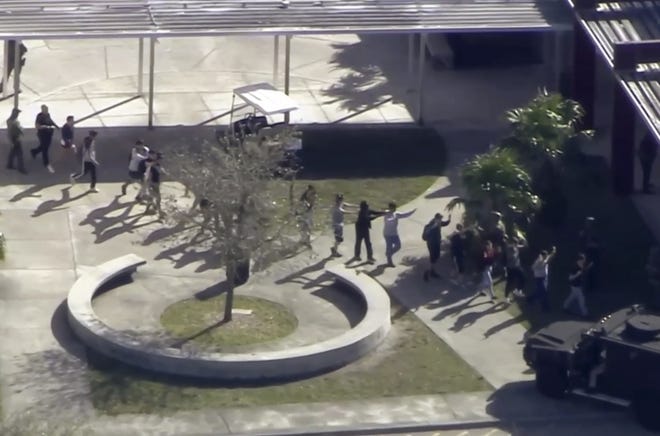 Students from the Marjory Stoneman Douglas High School in Parkland in Broward County evacuate the school following a shooting there on Wednesday. (WPLG-TV via AP)