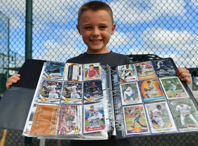Jordan Greene, 9, of Sarasota, displays his baseball card collection after getting an autograph from Pittsburgh Pirates prospect Cole Tucker on Wednesday in Bradenton. Wednesday was the first day of practice for pitchers and catchers. The Pirates' first full-squad workout is Monday, but some position players are already practicing. [Herald-Tribune staff photo / Mike Lang]