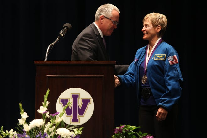 Steven E. Titus, President of Iowa Wesleyan University presents astronaut Peggy Whitson, with a medal during a Founders Day celebration Wednesday in the University Chapel. Whitson, who graduated from Iowa Wesleyan University in 1981, is the first woman to command the international space station, and holds records for cumulative days in space by any NASA astronaut and for total spacewalks by a woman. She also was the first woman to serve as Chief of the Astronaut office, a position she held prior to her most recent station command assignment, and has logged more days in space than any other woman. [John Lovretta/thehawkeye.com]