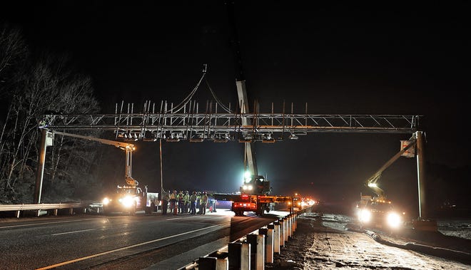 The gantry structure is bolted to pole on either side of Route 95 south, near Exit 5, early Thursday morning. The gantry is the first of more than a dozen planned in the state. [Providence Journal photo / Glenn Osmundson]