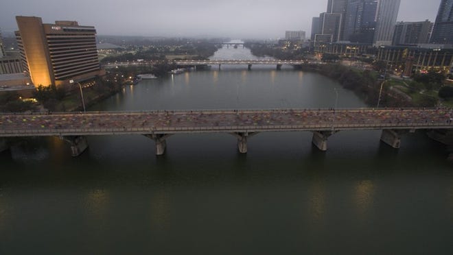 The Austin Marathon gets underway around 7am on a foggy Sunday morning, February 19, 2017. Runners make their way south across the Ann Richards Congress Avenue Bridge as they begin the full or half marathon distance. A slow shutter speed blurs the runners in the low light of the hour. ZACH RYALL/AMERICAN-STATESMAN 02/19/2017