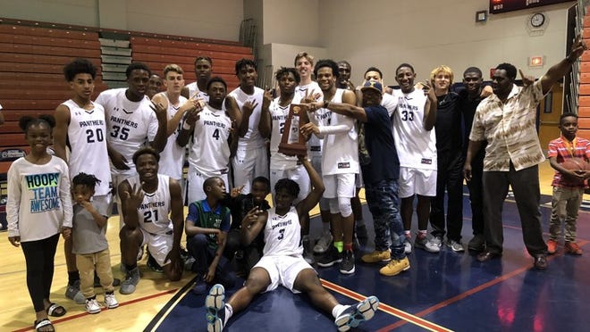 Members of the Dwyer boys basketball team celebrate their District 13-8A championship Friday night. (Jodie Wagner/Palm Beach Post)