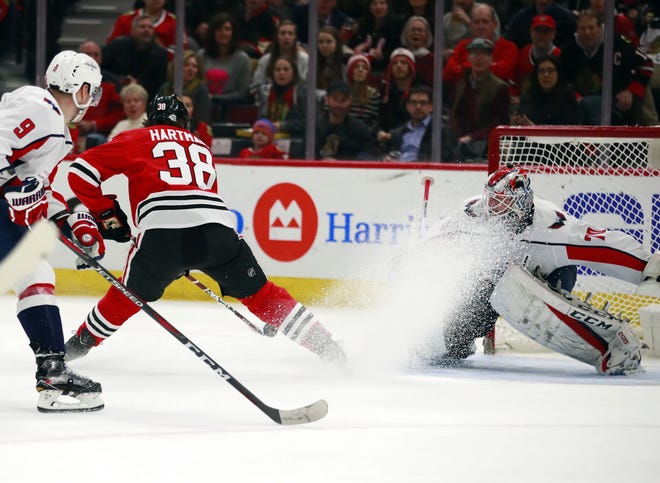 Chicago Blackhawks left wing Ryan Hartman (38) backhands a goal past Washington Capitals goaltender Braden Holtby during the second period of the game Saturday, Feb. 17, 2018, in Chicago. [JEFF HAYNES/THE ASSOCIATED PRESS]